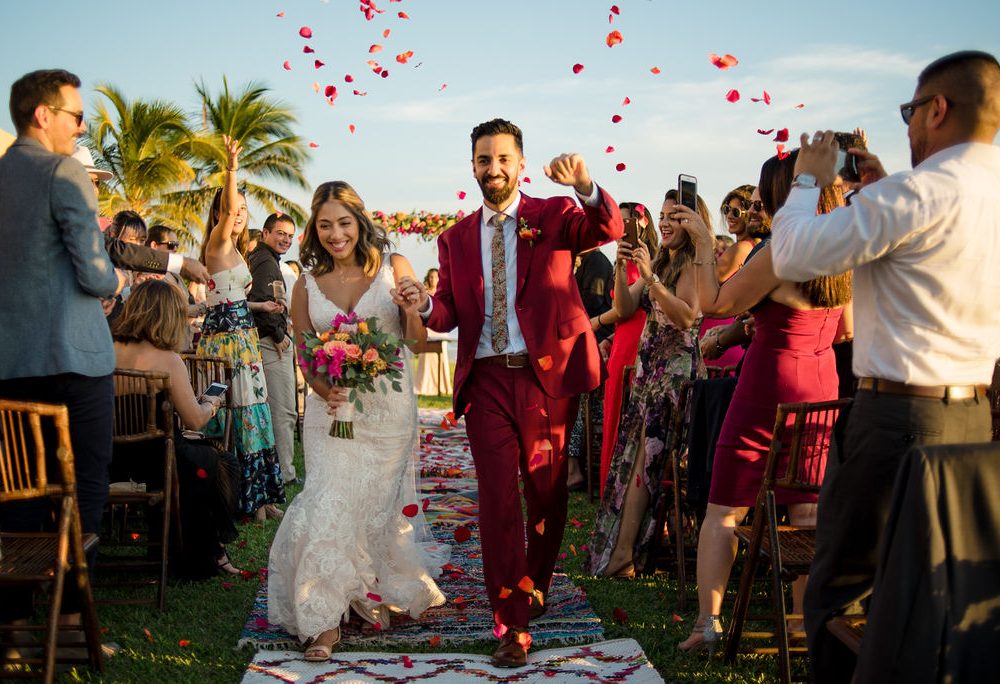 Bride and groom exit their ceremony to a petal toss at their destination wedding in Punta Mita, Mexico