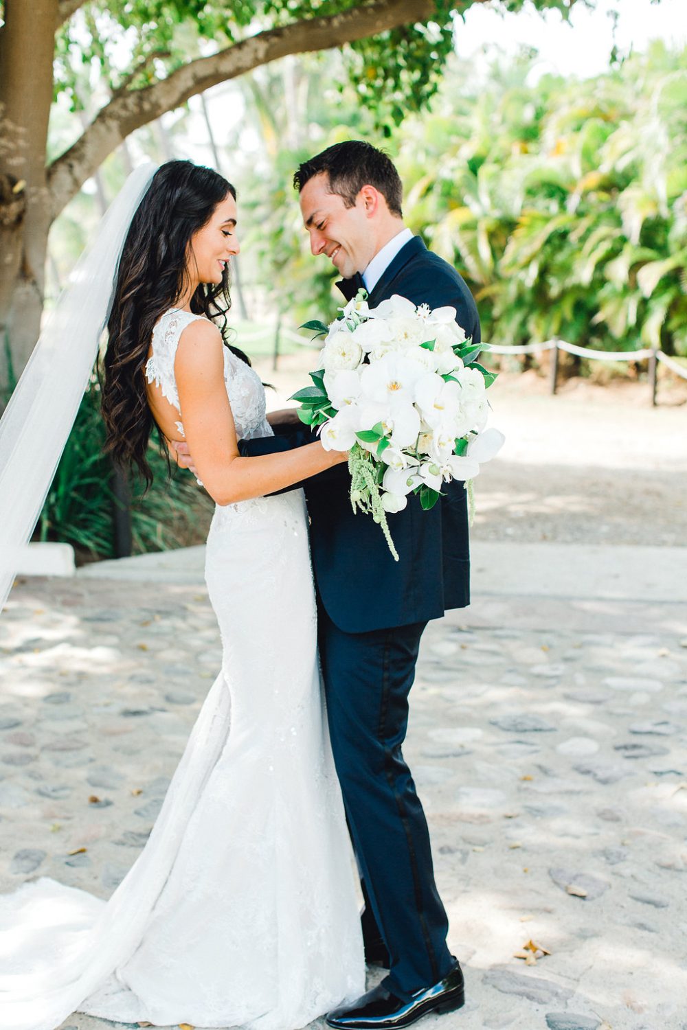 Bride and groom have a first look beneath a beautiful tree at their destination wedding in Punta Mita Mexico