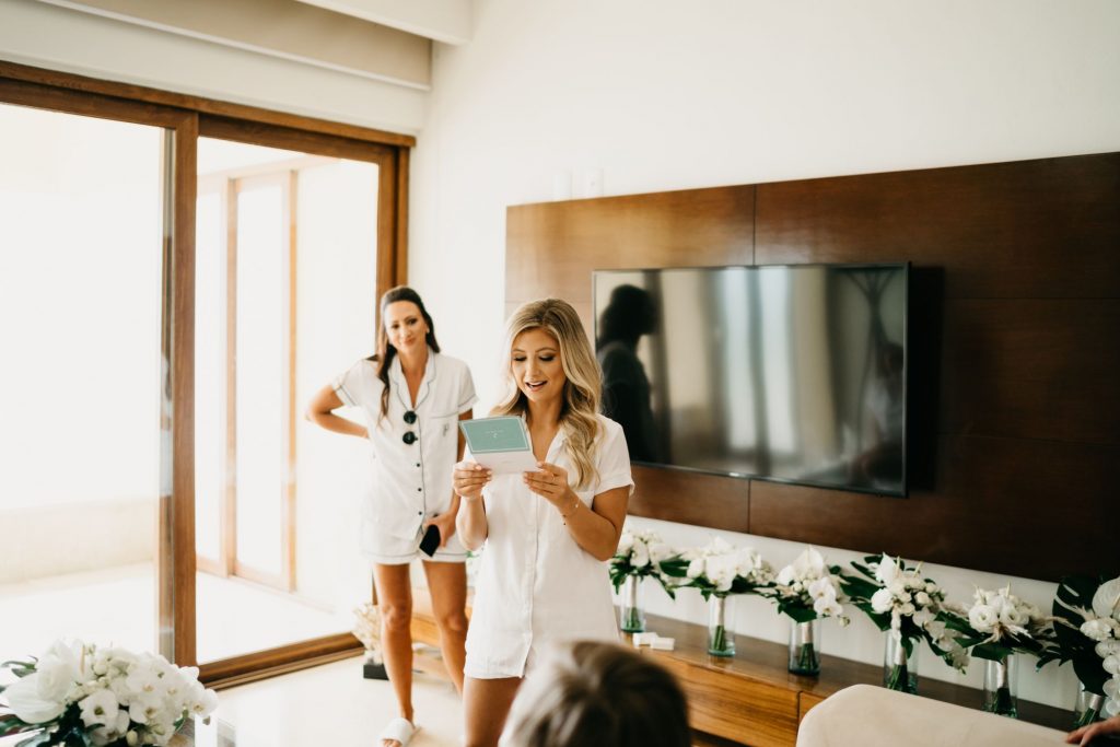 Bride reading a card as she prepares for her white wedding in Punta Mita Mexico