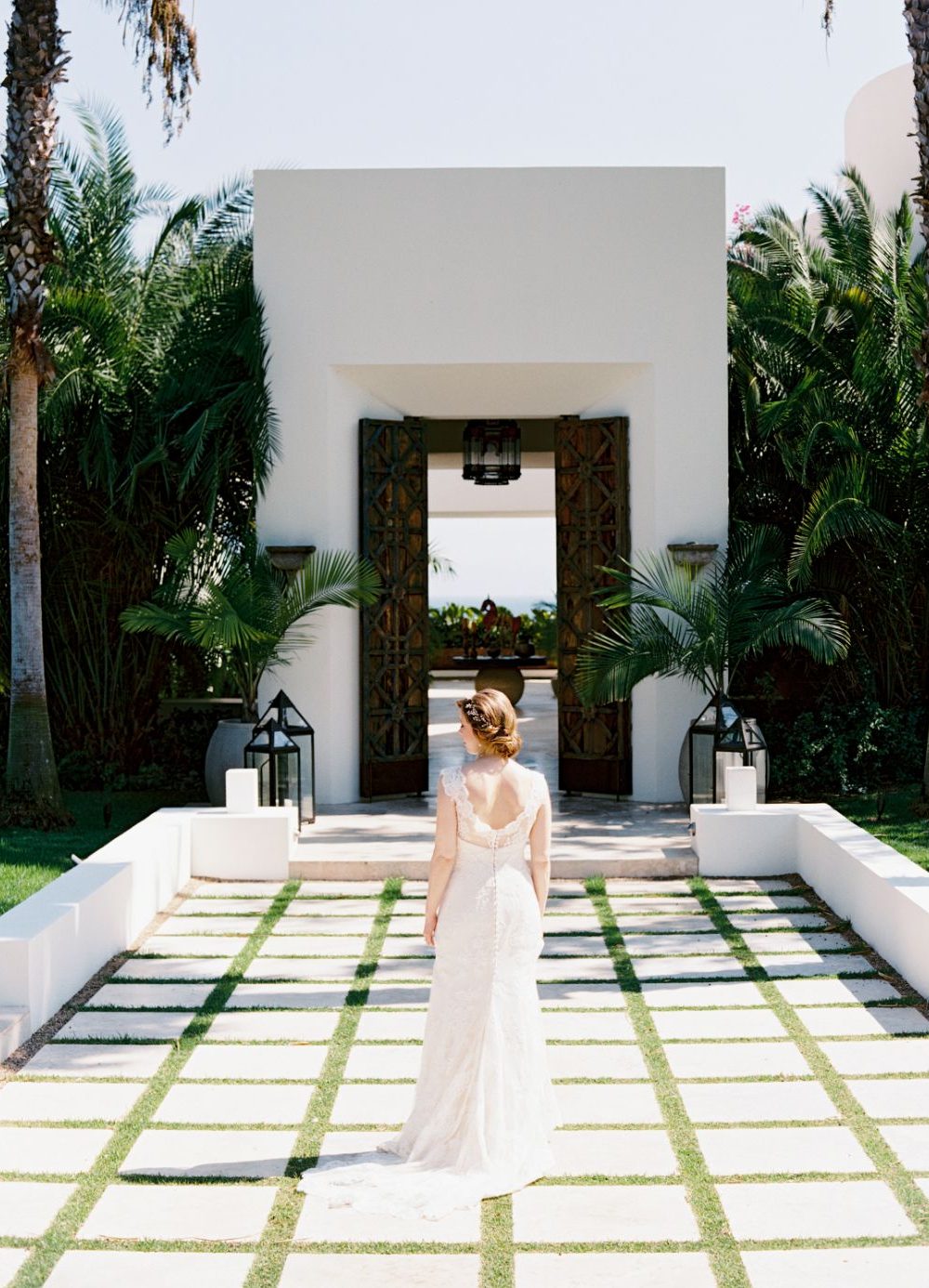 The bride posts in front of a stunning villa at her destination wedding in Punta Mita Mexico